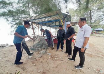 AZNAN Tamin (kanan) meninjau peralatan nelayan di Sungai Musoh, Pengerang, Johor yang rosak dibadai ombak besar dan angin kencang.