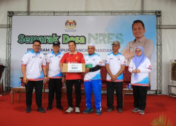 NIK NAZMI NIK AHMAD (tiga dari kiri) menyampaikan bantuan asnaf semasa Program Semarak Desa, Kampung Angkat MADANI di Kampung Aril, Melor, Kelantan. – UTUSAN/KAMARUL BISMI KAMARUZAMAN