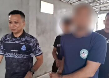 PEMPENGARUH media sosial (kanan) diiring polis keluar dari Mahkamah Sesyen Kemaman, Terengganu hari ini selepas mendapat perintah sambungan reman. - UTUSAN/NIK NUR IZZATUL HAZWANI NIK ADNAN