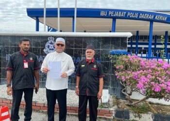 RAZMAN Zakaria (tengah) menunjukkan laporan polis terhadap akaun Facebook yang didakwa memfitnah beliau kononnya berkata Pas mempunyai peruntukan untuk membayar saman di Balai Polis Kerian, Perak.