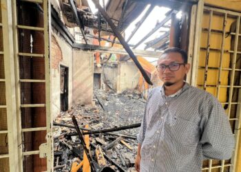 MUHAMMAD Firdaus Mustapha menunjukkan kesan kebakaran rumah di Kampung Alor Pasir, Pasir Puteh, Kelantan.UTUSAN/TOREK SULONG