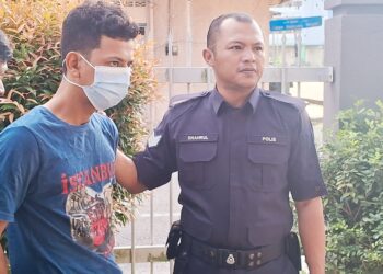 WAN Muhammad Faezyl Wan Mansor (kiri) diiring polis keluar dari Mahkamah Majistret Kemaman, Terengganu. - UTUSAN/NIK NUR IZZATUL HAZWANI NIK ADNAN