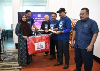 MOHD. Solehin Ramli (tiga dari kanan) menyampaikan bantuan kepada pengamal media yang terjejas banjir di majlis Suruhanjaya Koperasi Malaysia  bersama media di Kuala Terengganu, semalam. - UTUSAN/KAMALIZA KAMARUDDIN