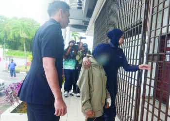 REMAJA perempuan berusia 14 tahun (tengah) yang didakwa mencederakan ibu saudaranya sendiri diiringi oleh dua anggota polis ketika tiba di Mahkamah Majistret Bukit Mertajam, Pulau Pinang, hari ini.-UTUSAN/IQBAL HAMDAN