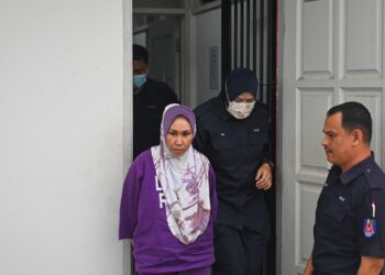 NORIZAN Ismail (kiri) dibawa keluar dari Mahkamah Majistret Dungun, Terengganu, hari ini. -UTUSAN/PUQTRA HAIRRY