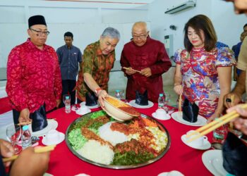 Ahmad Zahid Hamidi menuang kuah yee sang pecal ketika menghadiri Sambutan Tahun Baharu Cina bersama keluarga angkatnya, Beh Song Wan di Bagan Datuk, semalam,