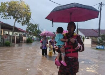 ANGGOTA bomba membantu memindahkan penduduk di Taman Desaru Utama, Kota Tinggi, Johor yang terjejas banjir ke lokasi selamat.