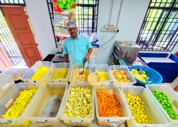 FAZIL Akasyah Othman (kanan) menunjukkan produk jeruk yang siap dibungkus untuk dijual kepada pelanggannya di premis perniagaannya di Kampung Perlis, Balik Pulau, Pulau Pinang. – UTUSAN/IQBAL HAMDAN