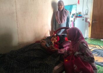 NOR Yasmin Natasya (berdiri) menerima kunjungan Pengerusi Cancer Survivor Malaysia (CSM) Zuraini Kamal yang menziarah kakaknya, Nor Amira di Kampung Nawar, Pokok Sena.