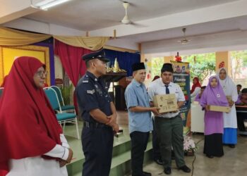 RAZAK Daud (tiga dari kiri) menyampaikan sumbangan kit peralatan pembelajaran Tunas Makmur kepada pelajar SMK Felda Jengka 24 di Jerantut, Pahang.