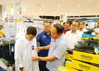 AZNAN Tamin membantu seorang pelajar yang menerima Bantuan Kasih Murid Johor memilih pakaian seragam di AEON Mall Tebrau, Johor Bahru.