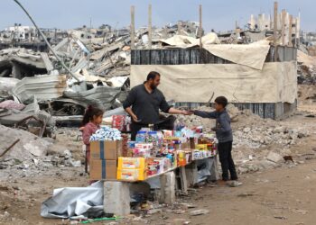 SEORANG lelaki menjual barangan keperluan di hadapan runtuhan bangunan yang musnah di sepanjang jalan Saftawi di Jabalia di utara Semenanjung Gaza.-AFP