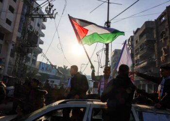 SEORANG lelaki mengibarkan bendera Palestin ketika orang ramai meraikan perjanjian gencatan senjata Hamas dan Israel di Gaza, pada 19 Januari lalu.- AFP