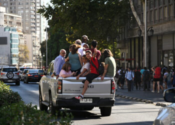 ORANG ramai berhimpit di belakang sebuah trak pikap akibat gangguan pengangkutan awam selepas bekalan elektrik terputus di Santiago, Chile.-AFP