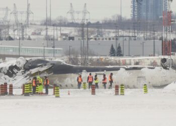 PASUKAN penyiasat memeriksa serpihan pesawat Delta Air Lines yang terbalik ketika mendarat di Lapangan Terbang Antarabangsa Pearson di Toronto, Kanada.-AFP