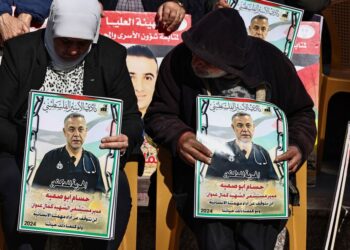 ORANG ramai mengangkat plakad yang mengandungi potret Pengarah Hospital Kamal Adwan, Dr. Hossam Abu Safieh yang ditahan Israel, semasa protes solidariti di bandar Ramallah, Tebing Barat, 14 Januari lepas.- AFP