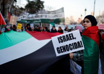 PENUNJUK perasaan memegang plakad bertulis 'Israel, genosid' semasa demonstrasi menyokong rakyat Palestin dan menuntut perang Gaza ditamatkan, di Madrid pada 18 Januari lepas.- AFP