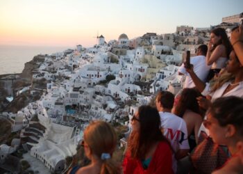 PELANCONG menunggu matahari terbenam di perkampungan Oia di pulau Santorini Yunani, pada 20 Julai 2024.- AFP