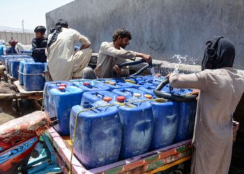 PENJUAL mengisi air ke dalam tong ketika musim panas di Jacobabad di wilayah Sindh, Pakistan.-AFP