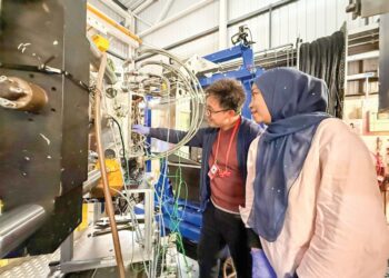 RAFIZA Abdul Razak bersama pelajar, Dickson Ling  menyediakan sampel untuk pengujian Engin-X di Rutherford Appleton Laboratory, United Kingdom baru-baru ini.