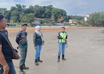 Pegawai Jabatan Perhilitan Negeri Sembilan, Shazatul Farina Abdul Latif (kanan) bersama tiga anggota lain membuat pemantauan di Pantai Cermin, Port Dickson susulan penampakan buaya di kawasan berkenaan kelmarin.-UTUSAN/NOR AINNA HAMZAH.