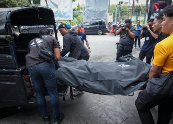 ANGGOTA polis membawa mayat suspek kes tembak di Setia City Mall yang ditembak mati di sebuah hotel di Pulau Ketam, Klang semalam. 
– UTUSAN/SADDAM YUSOFF