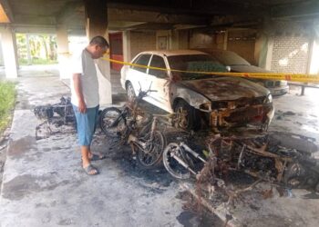 ANG Kok Meng melihat motosikalnya yang hangus terbakar di ruang parkir Blok H PPR 1 Paya Nahu di Sungai Petani - UTUSAN