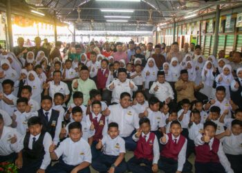 SIRAJUDDIN Suhaimee (tengah) bersama murid SK Menora pada pelancaran Kampung Menora sebagai Kampung Angkat Madani Jakim di Kuala Kangsar, Perak hari ini. - UTUSAN