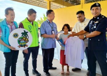 GARRY Kuan Pei Ern (dua kiri) semasa hadir ke majlis penyampaian sumbangan seragam sekolah 
di Kampung Mentua, Tumpat, Kelantan. – UTUSAN/ROHANA ISMAIL