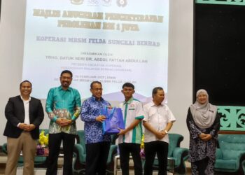 ABDUL Fattah Abdullah (tiga dari kiri) menyampaikan hadiah kepada seorang ahli koperasi pada Majlis Anugerah Pengiktirafan Perolehan RM1 juta Koperasi MRSM Felda Sungkai Berhad di MRSM Ulul Albab Felda Trolak, Sungkai, Tanjung Malim hari ini. - UTUSAN