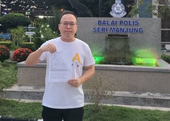 LING Jin Shean menunjukkan laporan polis terhadap dua pempengaruh media sosial yang dibuatnya di IPD Manjung, Seri Manjung semalam. - UTUSAN