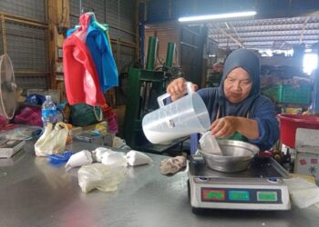 ROHAIDA Othman mengisi santan segar ke dalam plastik untuk dijual  di premisnya di Pasar Singgah Selalu, Sungai Petani, Kedah.