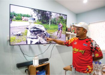 MOHD. SHAFIQ Johari menunjukkan gambar kemalangan menimpa pemandu Malaysia di Thailand yang diuruskan GoThai.my ketika ditemui di pejabatnya di Napoh, Kubang Pasu, Kedah. – UTUSAN/SHAHIR NOORDIN