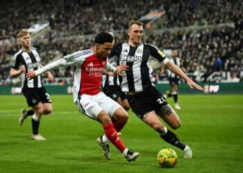 Pemain pertahanan Arsenal, Gabriel Magalhaes (kiri) mengasak pertahanan Newcastle, Dan Burn dalam aksi separuh akhir Piala Liga di St James' Park, pagi ini. - AFP