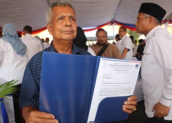 DONDONG Lonjong menunjukkan surat kelulusan rumah baharu yang diterima daripada Menteri Besar, Datuk Seri Wan Rosdy Wan Ismail di Bandar Tun Razak, Jengka, Pahang. - UTUSAN/SALEHUDIN MAT RASAD