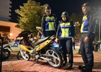 NORAINI Mohd Nawi (dua dari kanan) memeriksa motosikal menggunakan nombor pendaftaran kenderaan lain dan cukai jalan tamat tempoh sewaktu Ops TBC 2025 berhampiran bulatan Tuanku Syed Putra, Kangar, Perlis, semalam. -UTUSAN/ASYRAF MUHAMMAD