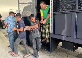 SUSPEK (kanan) yang disyaki menetak bapanya pada Isnin lalu tiba di Kompleks Mahkamah Kangar, Perlis, semalam. – UTUSAN/ASYRAF MUHAMMAD