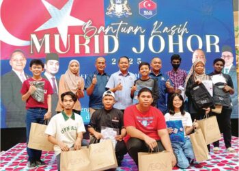 AZNAN Tamin (tengah) bersama penerima Program Bantuan Kasih Murid Johor di AEON Mall Tebrau, Johor Bahru, semalam.