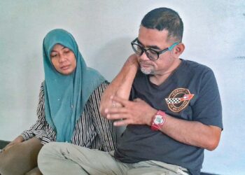 AHMAD NOR Al Faizan Jusoh (kanan) dan isterinya, Faridah Abdul Karim menunjukkan kesan luka di belahagian tangan ketika ditemui di rumahnya di Kampung Mak Chili, Kemaman, Terengganu. - MINGGUAN/NIK NUR IZZATUL HAZWANI NIK ADNAN