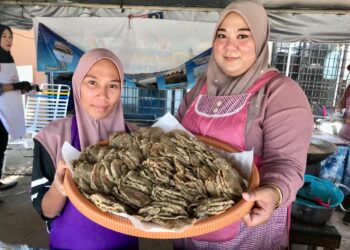 NADIA Hassan (kiri) menunjukkan Keropok Laila yang dijual di gerainya di Kuala Besar, Kota Bharu, Kelantan. - UTUSAN/ROSLIZA MOHAMED