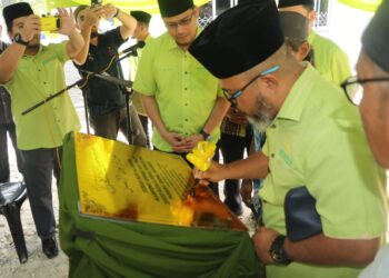 ASMADI Abdul Rahman menandatangani plak perasmian Surau Nur Al-Insan Kampung Orang Asli Pasu, Kuala Krau di Temerloh, Pahang.