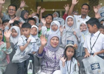 NANCY Shukri bersama sebahagian pelajar yang menerima sumbangan Kembali ke Sekolah yang diadakan Kuching baru-baru ini.