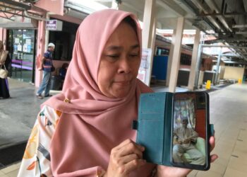 ZURAINI Isa menunjukkan  gambar Allahyarham Rosli Yusof di Hospital Pakar Universiti Sains Malaysia (HPUSM) Kubang Kerian, Kota Bharu, Kelantan. – MINGGUAN/ ROSLIZA MOHAMED