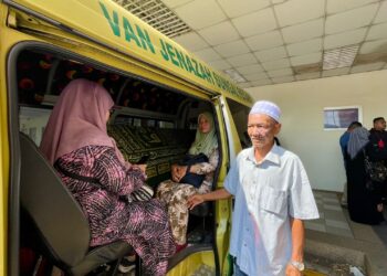 MOHD. Zaini Hashim (kanan) dan ibu Muhammad Muslim, Siti Ramnah Samsuri (tengah) mengiringi jenazah anak mereka untuk dibawa pulang bagi urusan pengebumian di Kuala Kedah, Kedah.