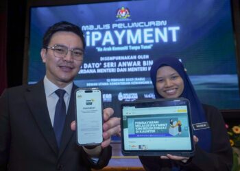 KAKITANGAN Kementerian Kewangan menunjukkan aplikasi iPAYMENT pada Majlis Peluncuran Sistem iPAYMENT di Kementerian Kewangan, Putrajaya. - UTUSAN/FAISOL MUSTAFA