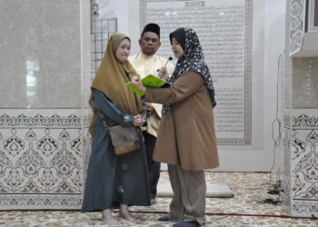 Tan Mei Paik (kiri) mengucapkan dua kalimah syahadah yang dipimpin Che Siti Nuraisyah Che Suhaimi sambil disaksikan oleh Zolkifly Md. Lazim di Masjid Permatang Janggus, Permatang Pauh, Pulau Pinang.