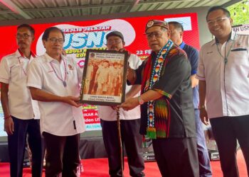 PANDIKAR Amin Mulia (dua kanan) semasa menerima cenderamata pada Program Jelajah USNO Peduli Rakyat di Zon 3 di Kampung Warisan Inanam di Kota Kinabalu, Sabah hari ini.