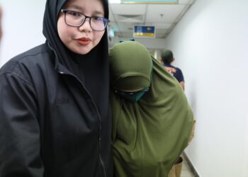 ZALINA Bidin (kanan) yang dituduh melakukan pengubahan wang haram dibawa keluar dari Mahkamah Sesyen Kuala Terengganu.  - UTUSAN/PUQTRA HAIRRY ROSLI