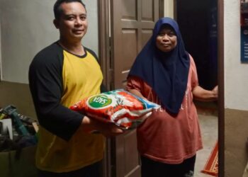 KAMARUL Azman Khamis menyampaikan sumbangan kepada isteri seorang pesakit saraf 
di Kampung Pong Utara, Kuala Nerang.-UTUSAN