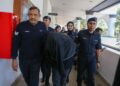 ANGGOTA polis mengawal tertuduh yang berhadapan pendakwaan melakukan amang seksual fizikal di Mahkamah Sesyen Alor Setar, hari ini. - UTUSAN/ SHAHIR NOORDIN